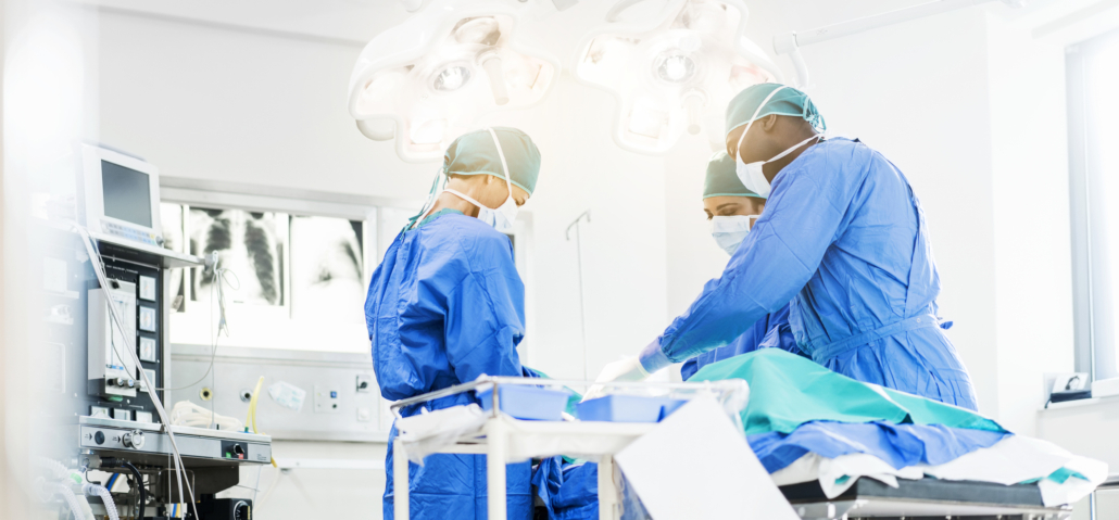 Surgeons operating below lighting equipment